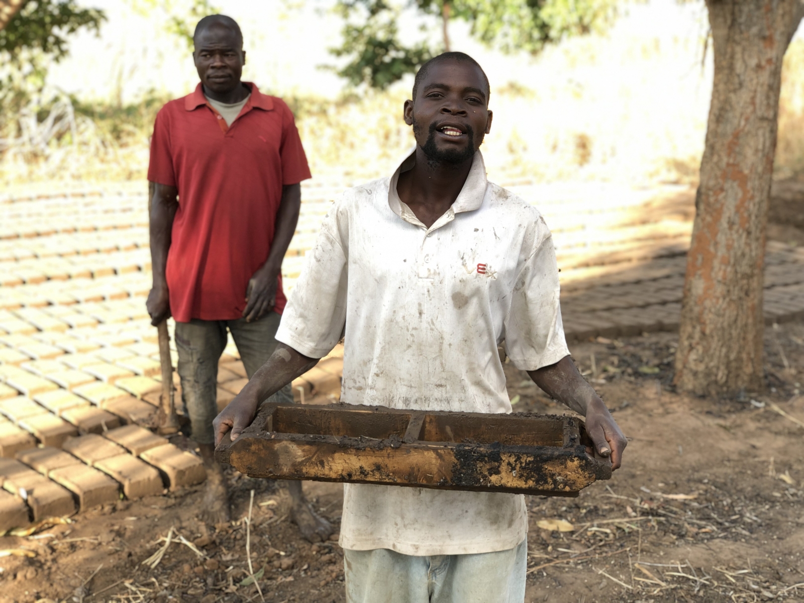 Guys making bricks for a new home using water from the well.